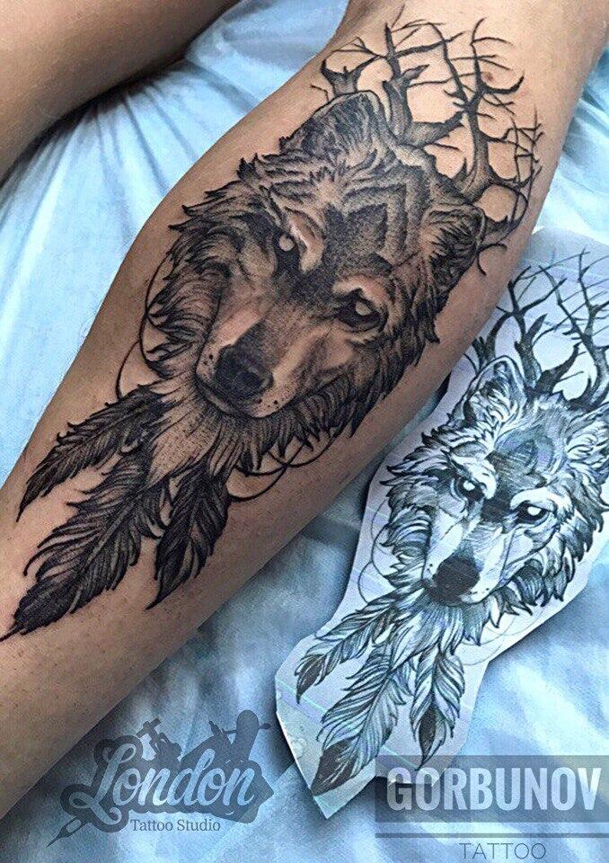 Фото тату Волк с перьями и деревьями