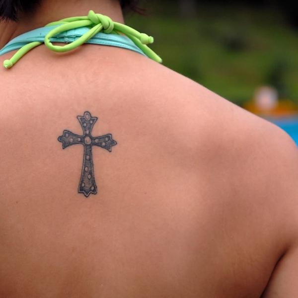 Фото тату Маленький крест на спине у дев